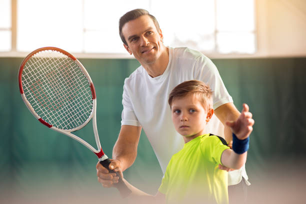 istock Joyful father coaching his child in tennis game 690886414