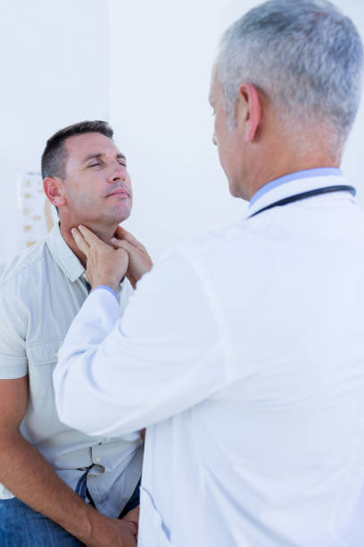istock Doctor examining his patient neck 690886426