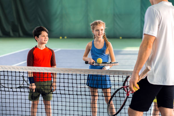 istock Male tennis trainer teaching children 690886614