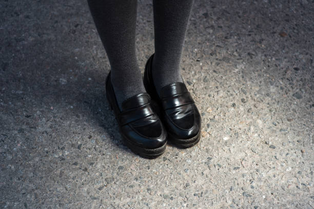 Retro Style Image Of School or student Girl's Feet In Uniform. black elegant shoes stock photo