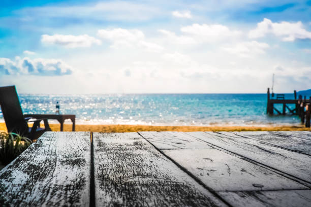 istock Wood table top on blue sea & sky background 690890778