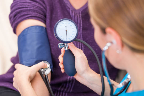 la medición de la presión arterial - medical assistant fotografías e imágenes de stock