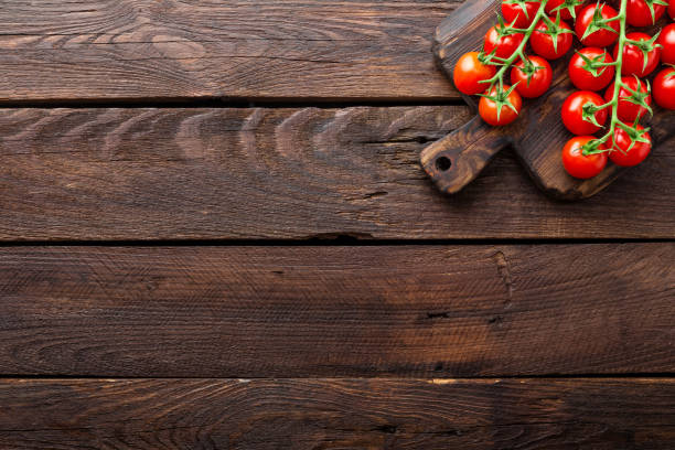 istock Fresh cherry tomatoes on twigs on wooden table, top view 690897182