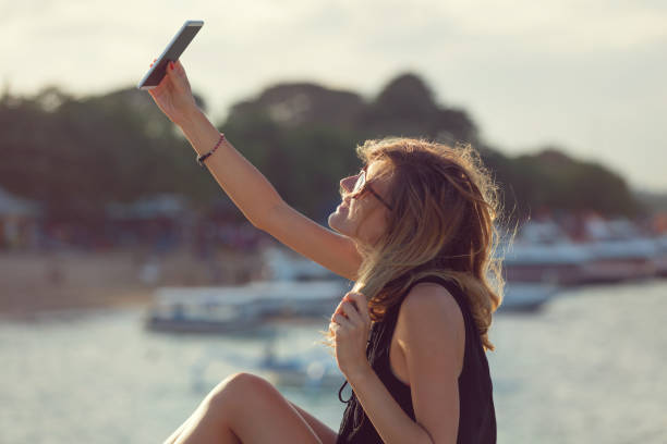 istock Attractive cute girl doing selfie on the beach. 690899852