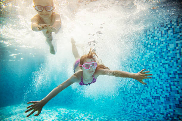 istock Happy kids swimming underwater 690900168