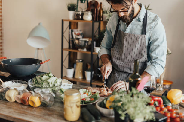 istock Young adult preparing meal in the kitchen 690900360