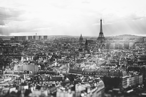 Paris, France - May 9, 2013: Black and white fisheye wide-angle (16mm lens attached to a full-frame DSLR camera) of the Eiffel Tower and the nearby streets in Paris, France. Crowds of tourists are seen in the streets and on the sidewalks nearby and underneath the Eiffel Tower. The Eiffel Tower is the most famous Parisian Landmark. The building is named after the designer Gustave Eiffel and is 324 meters tall (the tallest structure in Paris). It is a global icon of France and the most-visited paid monument in the world.