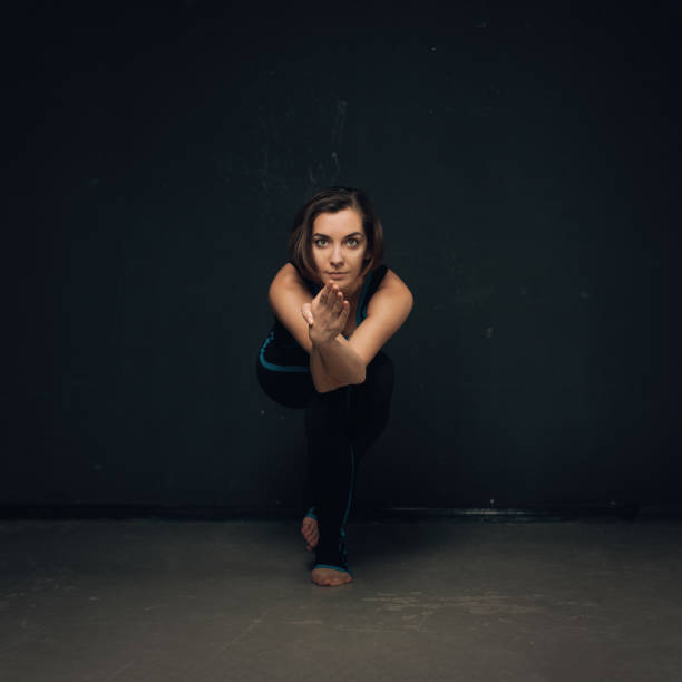 istock Woman practicing yoga against a dark texturized wall 691081164