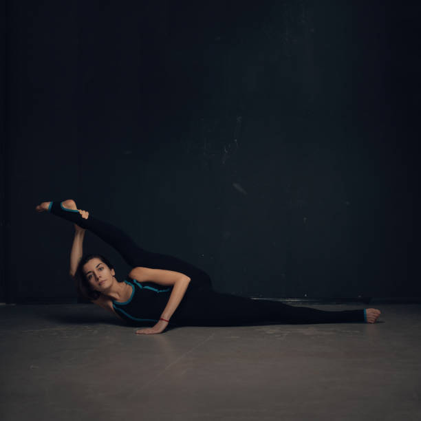 istock Woman practicing yoga against a dark texturized wall 691089296