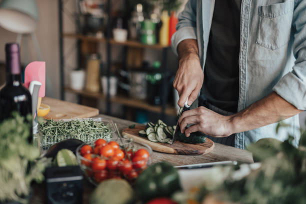 istock Close-up of man's hands chopping cucumber into slices 691096008