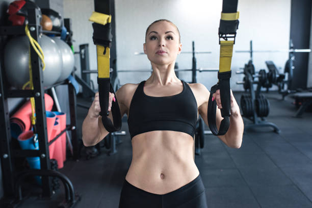 istock sportswoman training with trx resistance band 691099784