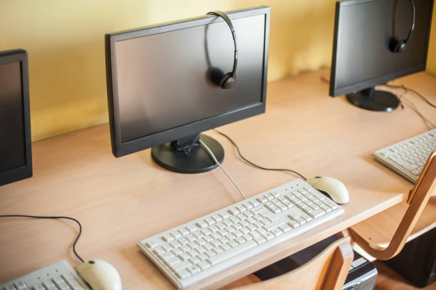 istock Row of computers with headphones on desk in primary school 691115092