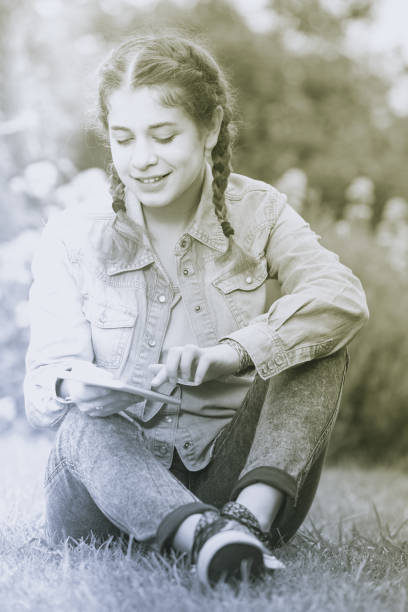 istock young girl using digital tablet while lying in green spring  garden 691122362