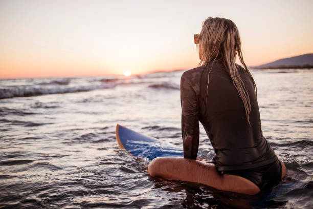 istock Woman sitting on surfboard 691123338