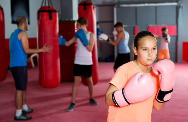 istock Girl with boxing gloves posing in defended stance 691126848