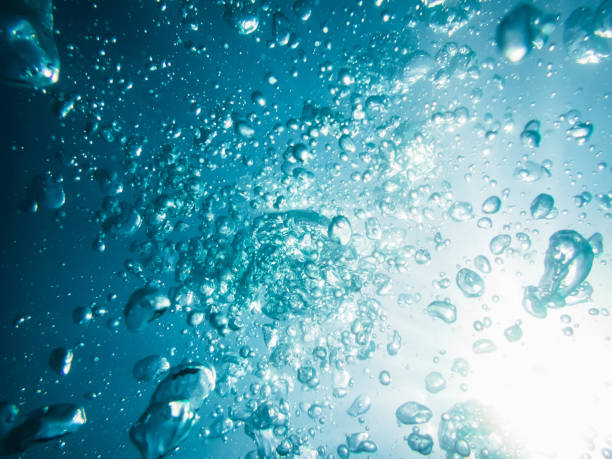 istock Bubbles and sun rays in underwater, in blue sea. 691127352