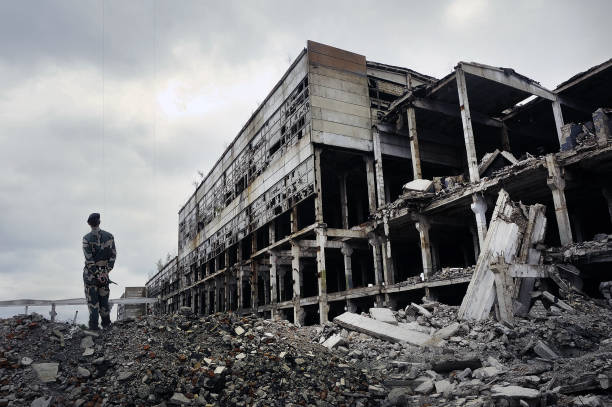 soldier in military uniform stands on the ruins - ucrania imagens e fotografias de stock