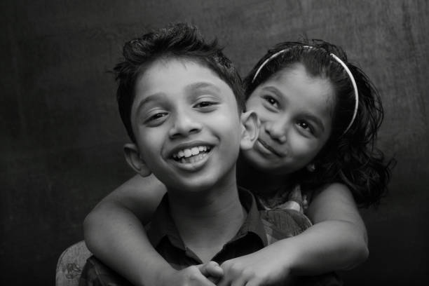 черно-белый портрет счастливого мальчика и девочки - horizontal black and white toned image two people стоковые фото и изображения