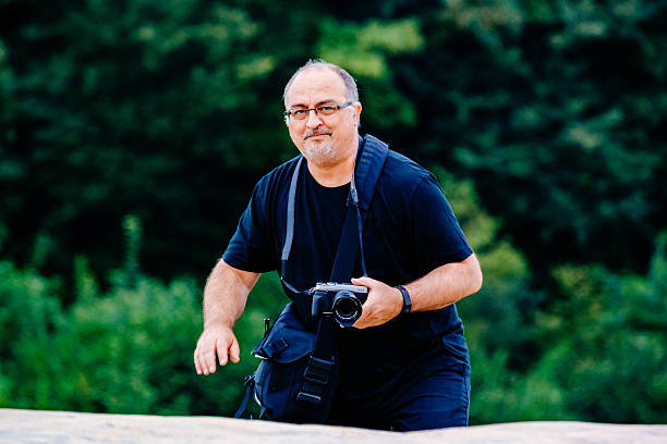 istock Portrait Of Man With Camera Against Trees 691151023