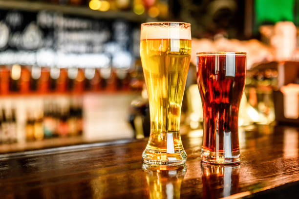 istock Glass of light and dark beer on a pub with bokeh background 691153220
