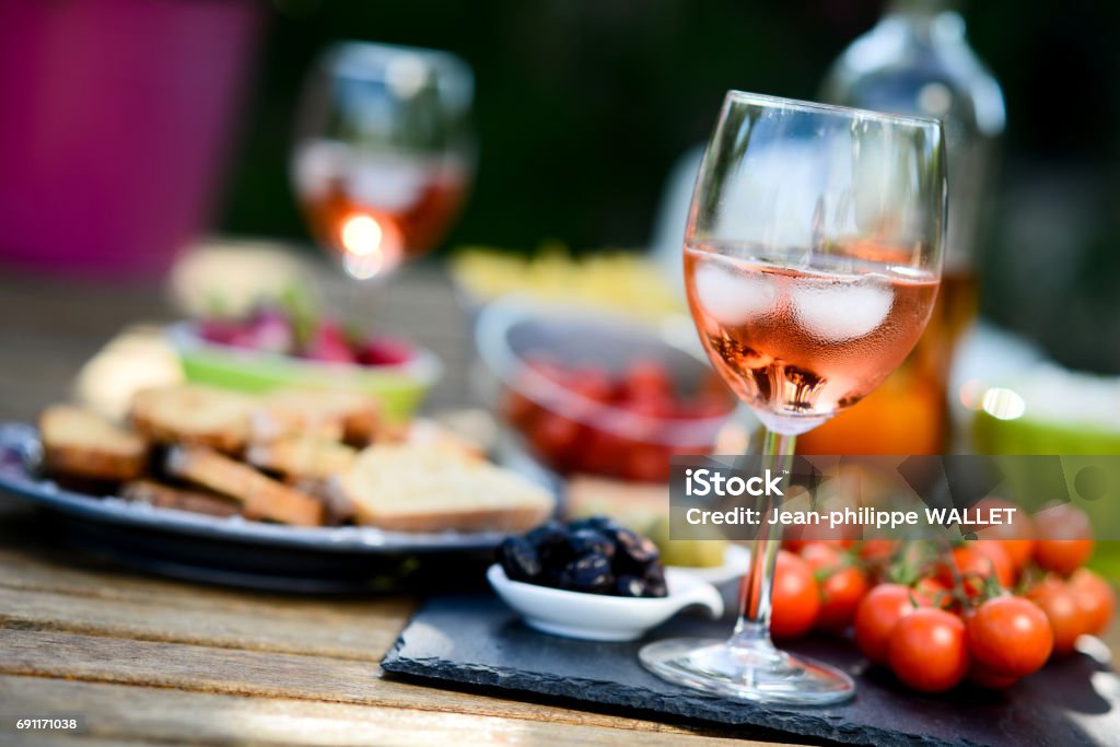 holiday summer brunch party table outdoor in a house backyard with appetizer, glass of rosÃ© wine, fresh drink and organic vegetables Wine Stock Photo