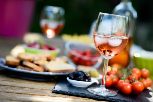 férias verão um brunch festa mesa ao ar livre em um quintal de casa com aperitivo, copo de vinho rosé, bebida fresca e legumes orgânicos - wine glass appetizer bottle - fotografias e filmes do acervo