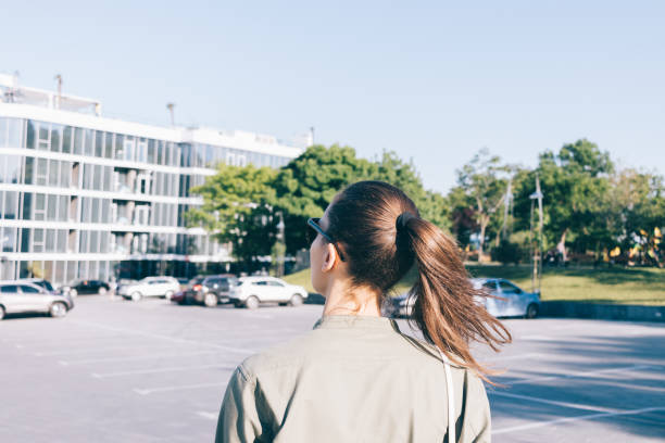 giovane donna con lunghi capelli castani che camminano in città in estate - ponytail brown hair tourist women foto e immagini stock