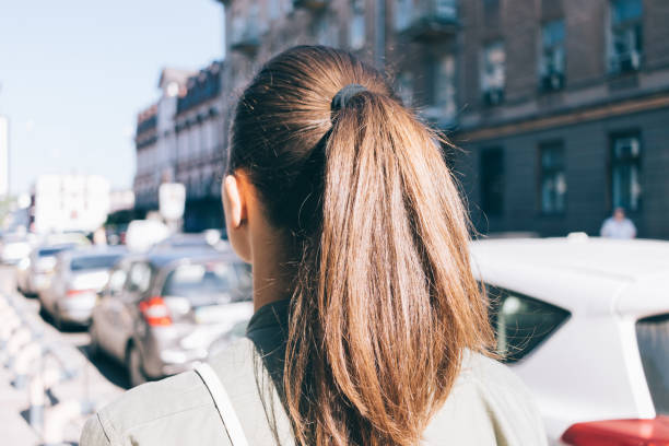 hermosa mujer joven con cabello largo castaño, pasear por la ciudad en verano - ponytail brown hair tourist women fotografías e imágenes de stock