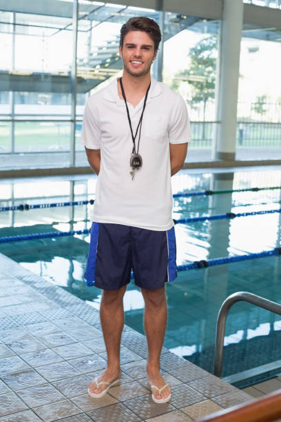 istock Swimming coach standing by the pool smiling at camera 691186304