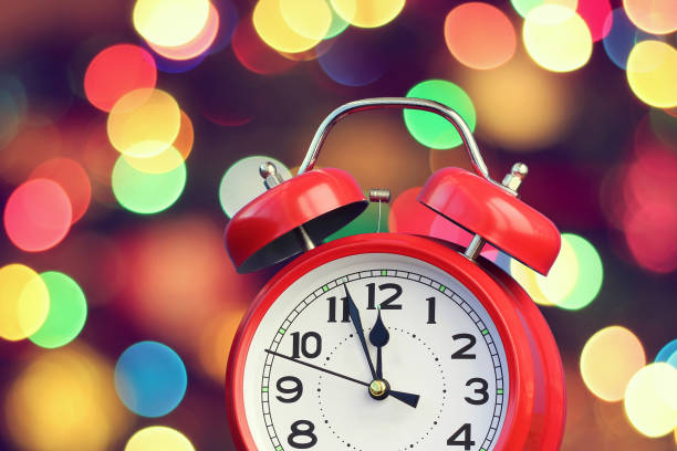 istock Red retro alarm clock at twelve o'clock on the background with bokeh. 691187496