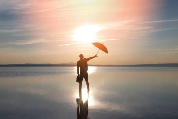 businessman with parasol on sea