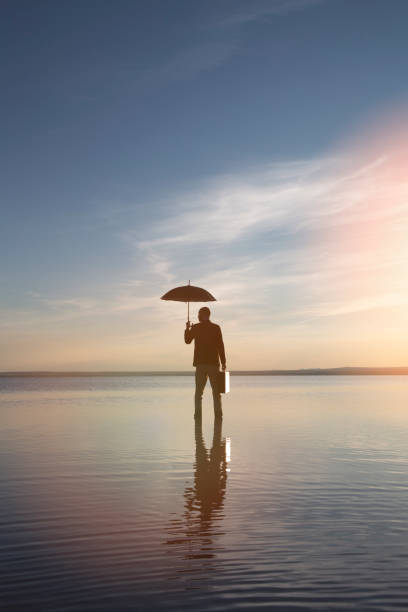 istock businessman with parasol on sea 691202938