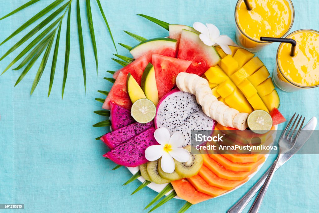 Assortimento di frutti tropicali con frullato di mango - Foto stock royalty-free di Frutto tropicale