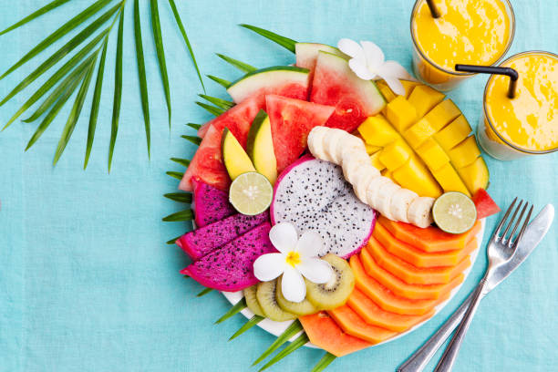 トロピカル フルーツの盛り合わせとマンゴーのスムージー - tropical fruit ストックフォトと画像