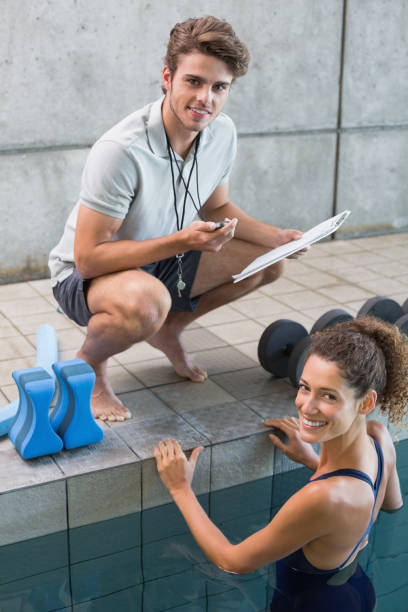 istock Swimmer with her coach poolside smiling at camera 691214888