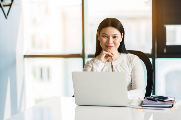 istock Positive charming lady sitting at her workplace 691217510
