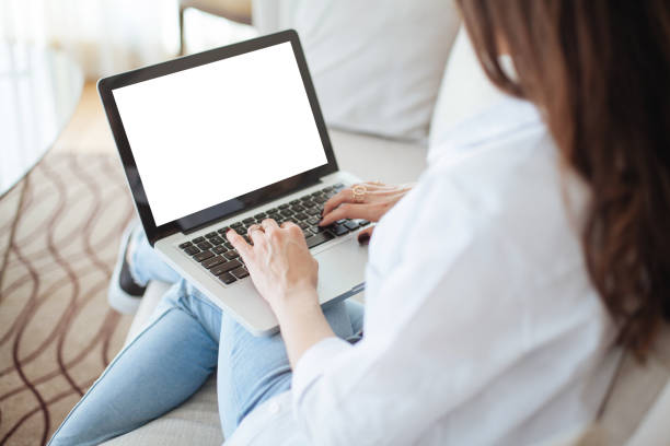 Cropped image of woman using laptop with blank screen Cropped image of woman using laptop with blank screen looking over shoulder stock pictures, royalty-free photos & images