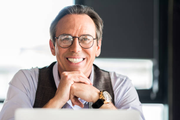 istock Pleasant mature businessman sitting at table with smile 691218118