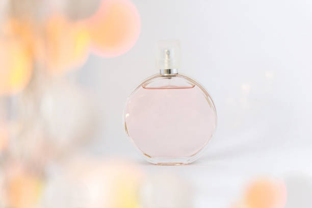 istock Bottle of perfume on a white background, grace and freshness, with bokeh and light shadow, grace and refinement. Copy space. 691221028