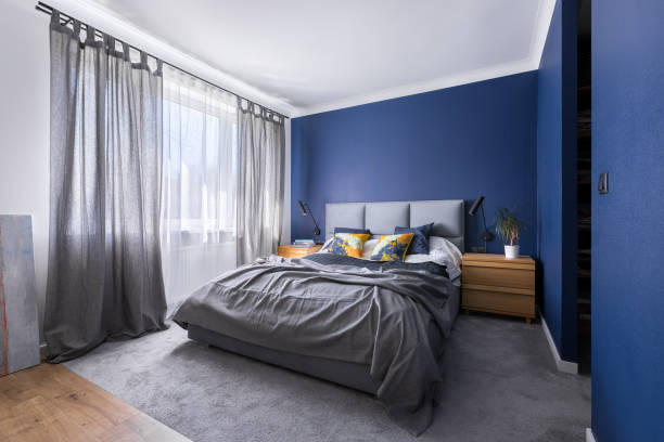Cobalt blue bedroom with bed Modern, cobalt blue bedroom with double bed, gray bedding, carpet and window royal blue curtains stock pictures, royalty-free photos & images