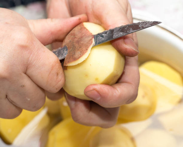 istock The cook cleans the potatoes with a knife 691226000