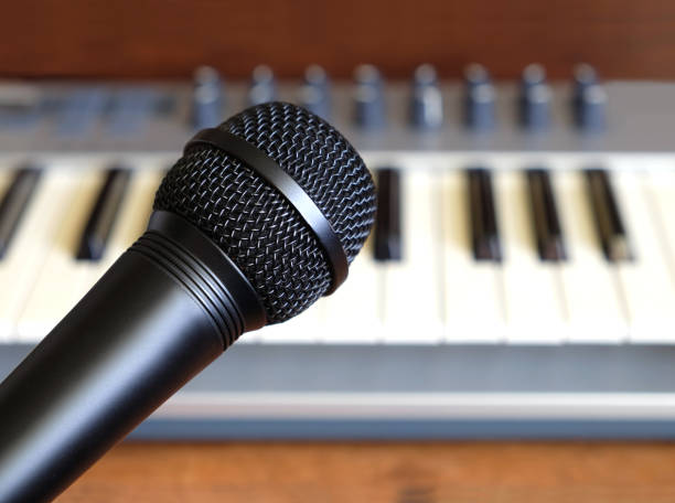 istock Black vocal microphone closeup against electronic synthesizer keyboard 691229016