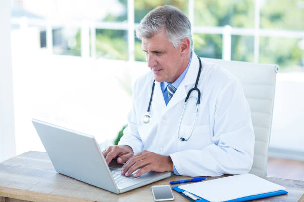 istock Serious doctor working on laptop at his desk 691232002