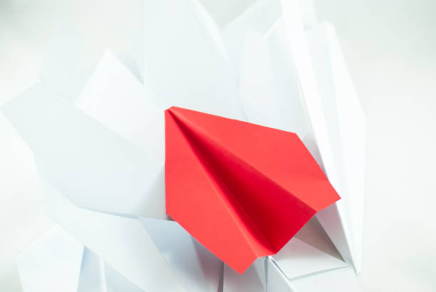 istock Red paper plane among white ones on white background, isolated. 691235786