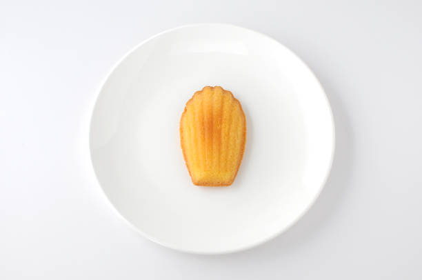madeleine französisch gebäck auf platte isoliert auf weißem hintergrund - muffin cake isolated small stock-fotos und bilder