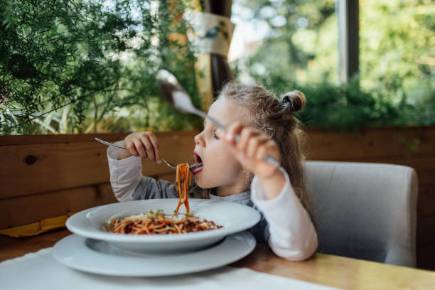 istock Little preschool girl is having a spaghetti dinner 691248308