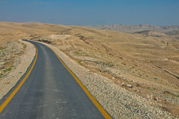 la strada per la santa lavra di san sabbas nel deserto israeliano - arid climate asphalt barren blue foto e immagini stock