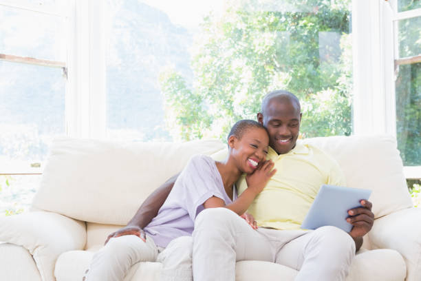 istock Happy smiling couple using laptop on couch 691258686