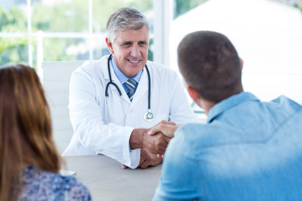 istock Smiling doctor greeting happy couple 691259044