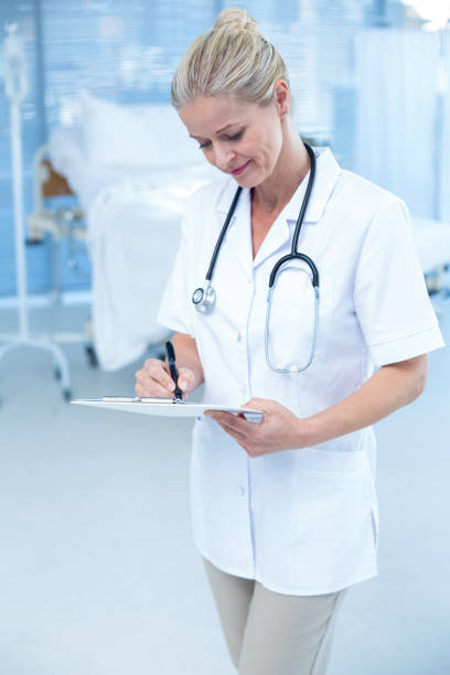 istock Beautiful smiling doctor writing on clipboard 691263458